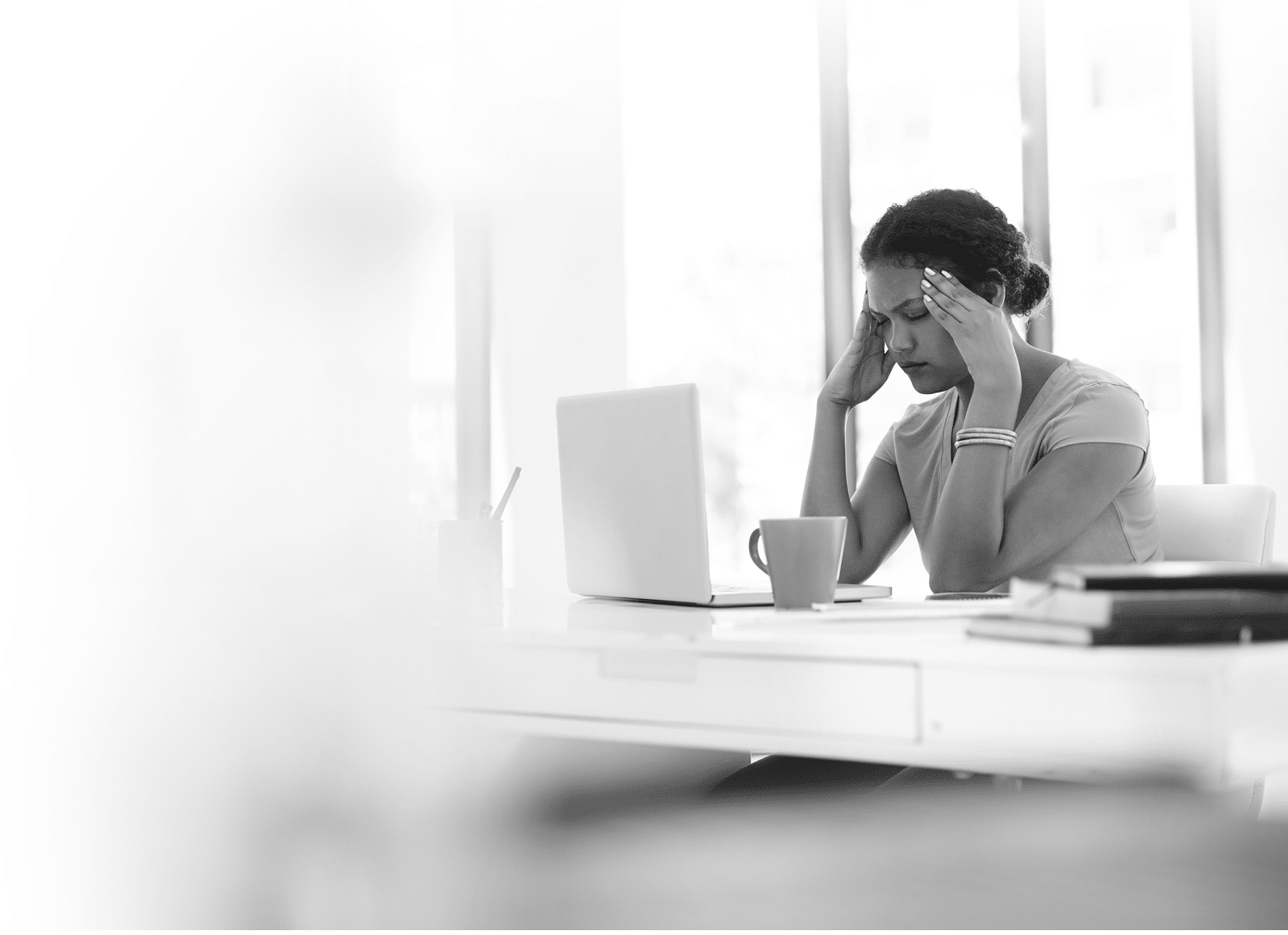 Shot of a young businesswoman experiencing stress at her desk in a modern office